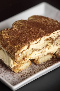 Beyaz bir tabakta tiramisu porsiyonu