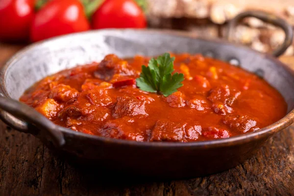 stock image hungarian goulash with bread on wood