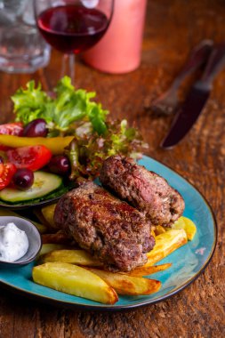 Salata ve patates kızartmalı Yunan bifteki
