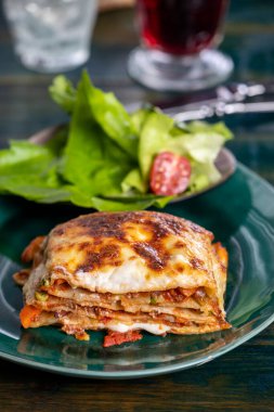 italian lasagna on a green plate
