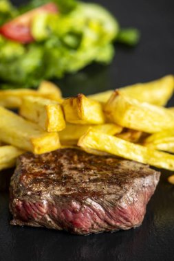 steak with fries on slate 