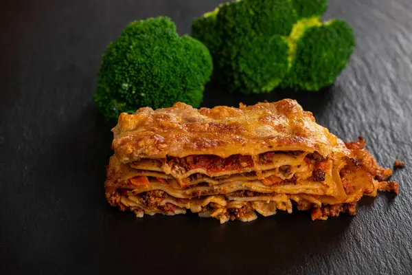 lasagna on slate with broccoli