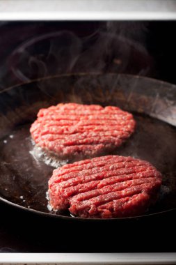 bir demir tavada iki sığır köftesi 