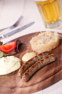 two bratwurst sausages on a wooden plate  clipart