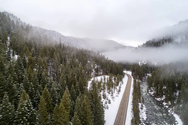 在大雾弥漫的山谷中 汽车在河边的路上行驶 — 图库照片