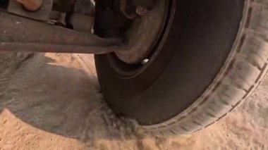 Kirli bir yolda tekerlek manzaralı bir kamyonun altında.