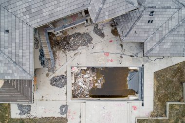 Top-down view of a neglected building featuring graffiti and scattered debris. The dilapidated structure and empty premises evoke themes of urban decay and abandonment. clipart