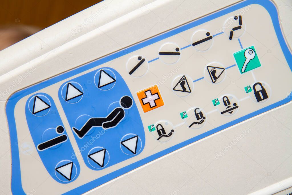 A white and blue device with a lot of buttons from a hospital bed