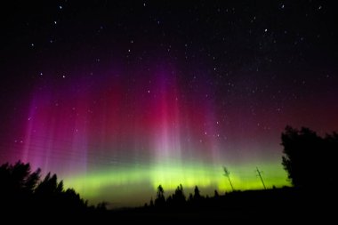 Mor aurora borealis ile güzel bir gece gökyüzü. Gökyüzü yıldızlarla dolu ve aurora ışıldıyor.