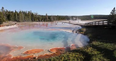 Kırmızı ve turuncu kenarlı güzel mavi bir göl. Su sakin ve gökyüzü berrak.