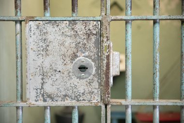 Paslı metal bir kapının, anahtar deliği ve kilidi olan yakın çekimi. Kilit paslanmış.