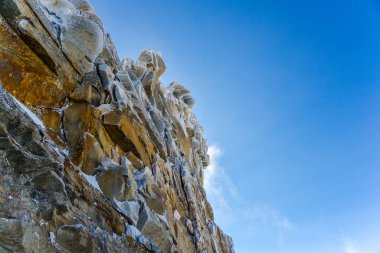 Mavi gökyüzü ile kayalık uçurum
