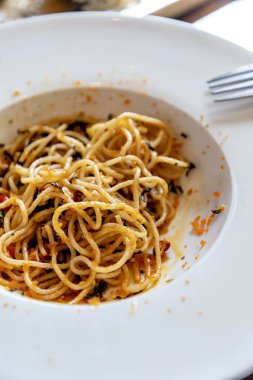 Turuncu karides yumurtası ile karıştırılmış spagetti, beyaz yuvarlak bir tabakta yenmiş. Tabakta hiç sebze yoktu. Dağınık karides yumurtası taşıma bozukluğu. Seçici odak.