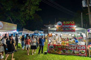 Bangkok, Tayland - 8 Aralık 2022: Birçok insan iyi restoranlardan yemek almak için yürür. 8-18 Aralık 2022 tarihleri arasında Lumpini Park 'taki Kızıl Haç Fuarı' nda seçilecek çok kişi var. Hareket bulanıklığı.