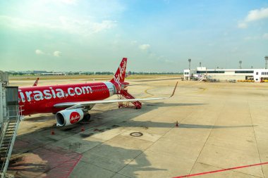 Bangkok Tayland - 28 Mart 2019: Tayland 'da popüler düşük maliyetli bir havayolu şirketi olan AirAsia' nın uçağı, açık ve güneşli bir günde yolcuları taşımaya hazır bir şekilde Don Mueang Uluslararası Havaalanı 'na park edilmiştir..