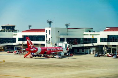 Bangkok Tayland - 19 Mayıs 2023; Tayland 'da popüler, düşük maliyetli bir havayolu şirketi olan AirAsia' nın uçağı, açık ve güneşli bir günde yolcuları taşımak üzere Don Mueang Uluslararası Havaalanı 'na park edilmiştir..