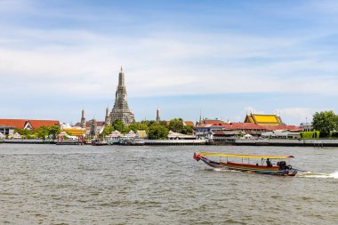 Bangkok Tayland - 28 Haziran 2023; Chao Phraya Nehri üzerinde uzun kuyruklu bir tekne denize açılıyor. Bangkok 'ta hızlı bir su yolculuğu ve turistler de Wat Arun' u (Şafak Tapınağı) görebiliyorlar..