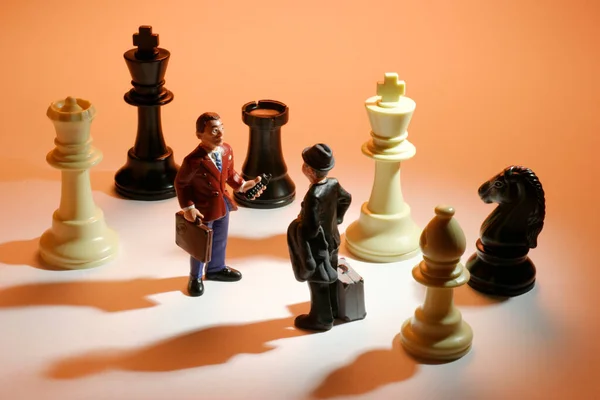 微型商人和国际象棋棋子 免版税图库照片