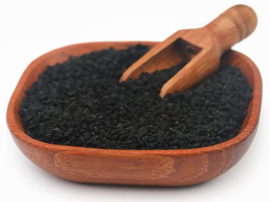 Nigella seeds with wooden scoop, over white background