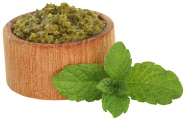 Tahta bir kasede taze yeşil yapraklı nane sosu.