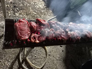 Yemek pişirirken barbekü yapan biftekler.