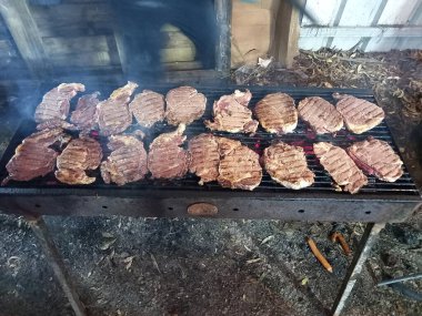 Yemek pişirirken barbekü yapan biftekler.
