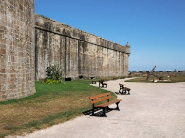 Saint-Malo 'da surları olan güçlendirilmiş bir kasaba. Arka planda banklar ve denizci demirleri var. Saint-Malo, İngiltere 'nin kuzeybatısında, Manş Denizi üzerinde yer alan bir liman kentidir. Ille-et-Vilaine Bölümü 'nün bir alt bölgesidir..
