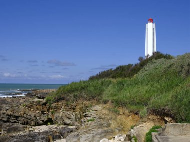 Fransa 'nın batısındaki Pays de la Loire bölgesinde Vendee Bölgesi' nde bulunan Les Sables dOlonne kayalık sahilindeki Armandeche deniz feneri.
