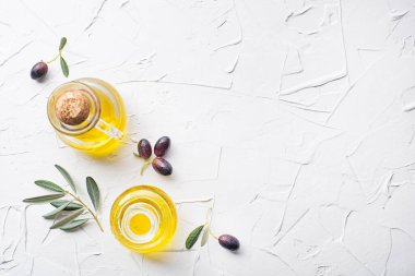 Zeytinli zeytinyağı şişeleri ve beyaz arka planda zeytin dalı