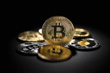 Bitcoin madeni paralar ve siyah arka planda altsikkeler. Sanal kripto para birimi kavramı.