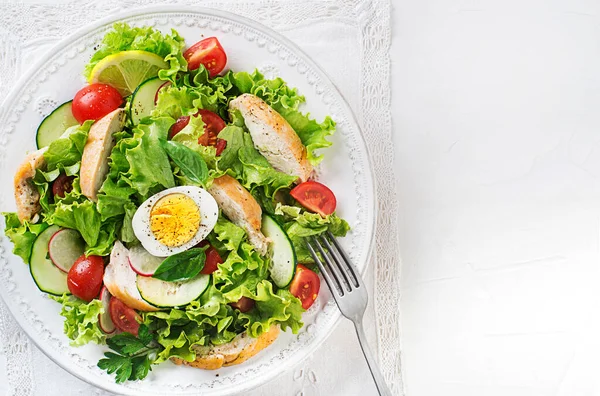 鶏の胸肉の野菜とゆで卵と新鮮な緑のサラダ白を背景にクローズアップ — ストック写真