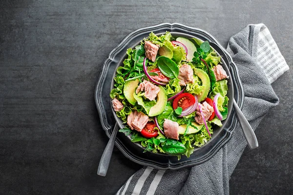 新鮮な緑の葉のサラダマグロアボカドとトマトを灰色のテーブルの背景に おいしくて健康的な食事のための概念 — ストック写真