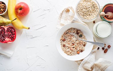 Taze meyve, fındık ve bal ile servis edilen bir kase kuru granola ve müsli. Yulaf ezmesi. Sağlıklı yiyecekler, diyet. Üst görünüm.