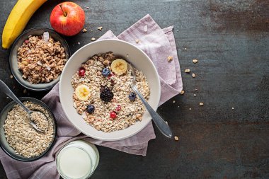 Taze meyve ile servis edilen bir kase kuru granola ve müsli. Yulaf ezmesi. Sağlıklı yiyecekler, diyet. Üst görünüm.