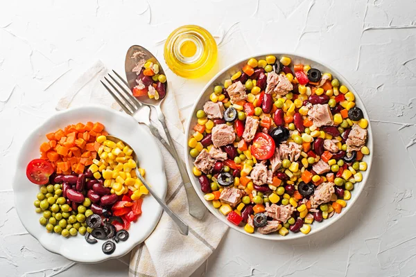 Healthy tuna salad with canned mixed vegetable on white table background. Mexican corn salad.