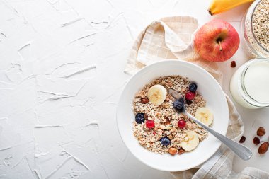 Taze meyve ve fındık ile servis edilen bir kase kuru granola ve müsli. Yulaf ezmesi. Sağlıklı yiyecekler, diyet. Üst görünüm.