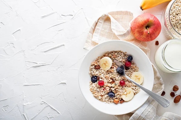 Taze meyve ve fındık ile servis edilen bir kase kuru granola ve müsli. Yulaf ezmesi. Sağlıklı yiyecekler, diyet. Üst görünüm.