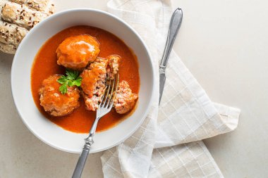 Fried meatballs braised in tomato sauce served on white table. Eating Beef roasted meatballs in tomato sauce.