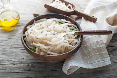 Traditional fresh and healthy sour turnip in bowl on wooden background clipart