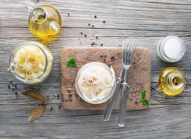 Geleneksel taze ve sağlıklı lahana turşusu ve tahta arka planda cam kavanozda ekşi şalgam..