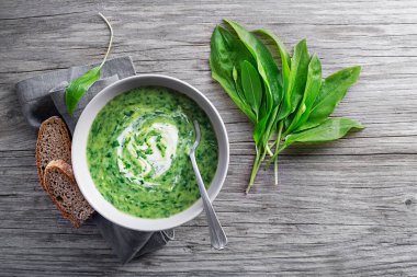 Taze Ramson soslu sağlıklı kremalı çorba ya da ahşap arka planda yabani sarımsak yaprakları. Sağlıklı bahar yemekleri konsepti