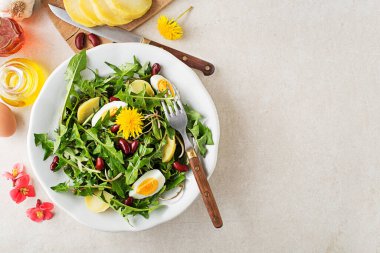 Yumurtalı karahindiba salatası, patates ve fasulye parlak masa arkasında yakın plan.