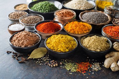 Yemek pişirmek için renkli otlar ve baharatlar. Hindistan ve Asya baharatları Gri taş arka planda yakın plan