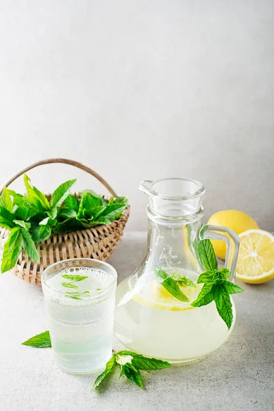新鮮なミントの葉とレモンのスライスと夏のさわやかなレモネードドリンク 新鮮な健康的な冷たいミントとレモン飲料 — ストック写真