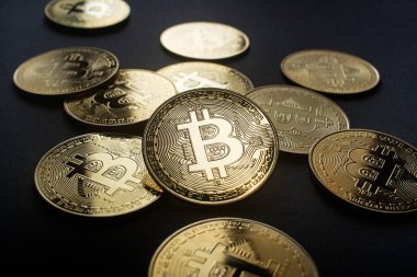 Bitcoin ve kripto para yatırım konsepti. Bitcoin kripto para sembolü ve siyah zemin üzerinde bozuk paralar. Kripto para değişimi ticareti..