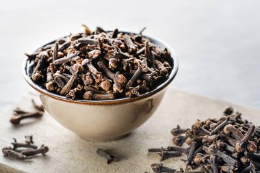 Karanfil baharatı. Gri arka plan baharat kavramında bazı kurumuş karanfiller kapanıyor.