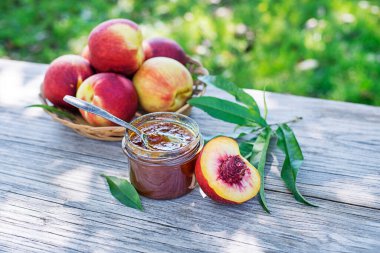 Güneşli bir günde şeftali reçeli ya da şeftalili cam kavanozda marmelat.