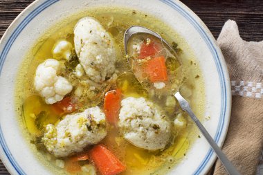 Fresh chicken soup with vegetable and semolina dumplings overhead shoot close up clipart