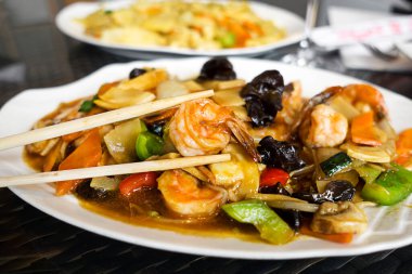 Çin yemeği sebze ve mantarlı karides kızartır.