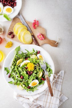 Yumurtalı karahindiba salatası, patates ve fasulye parlak masa arkasında yakın plan.